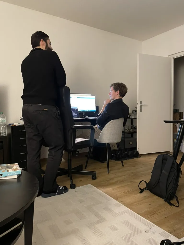 Zwei Teammitglieder besprechen Code an einem Monitor